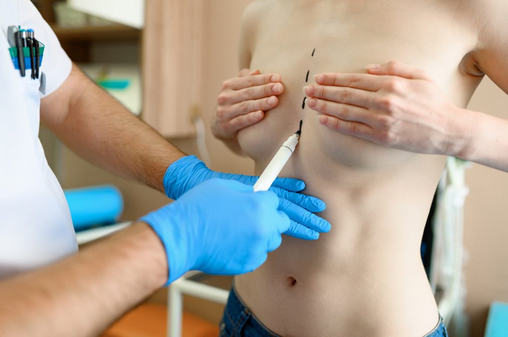 male surgeon prepares woman for surgery in clinic